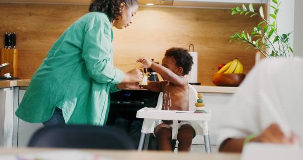 istock Mom feeds the baby in the kitchen 2201717874