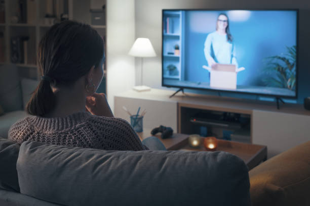 istock Woman watching an unboxing video on TV 2201719660
