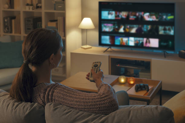 istock Woman watching TV at home and relaxing 2201719916