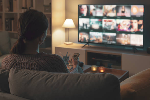 istock Woman watching TV at home and relaxing 2201719936