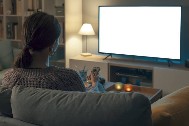 istock Woman watching TV and relaxing at home 2201720051