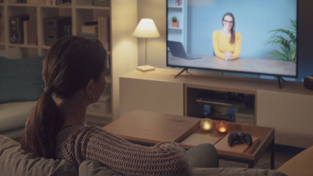 istock Woman watching an online course on her TV 2201720376