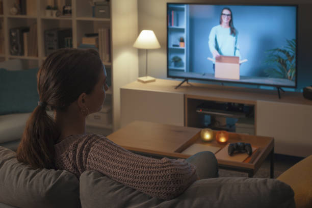 istock Woman watching an unboxing video on TV 2201720421