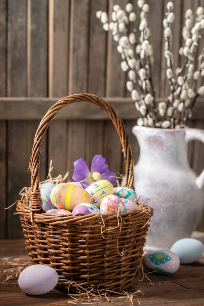 istock Decorated Easter eggs in a basket and vase with pussy willow branches 2201720425