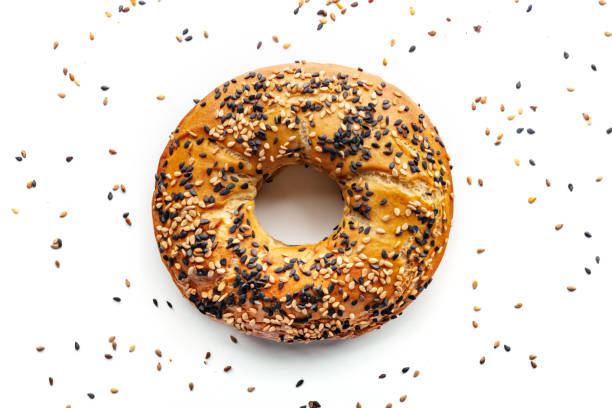 Bagel with sesame seeds, overhead flat lay shot on a white background