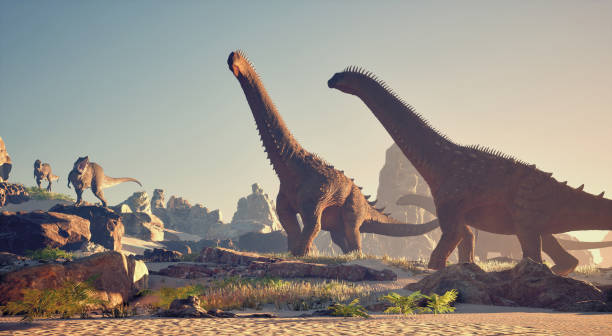 istock Dinosaurs roaming in a prehistoric landscape with rocky formations and lush vegetation during sunset 2201723037