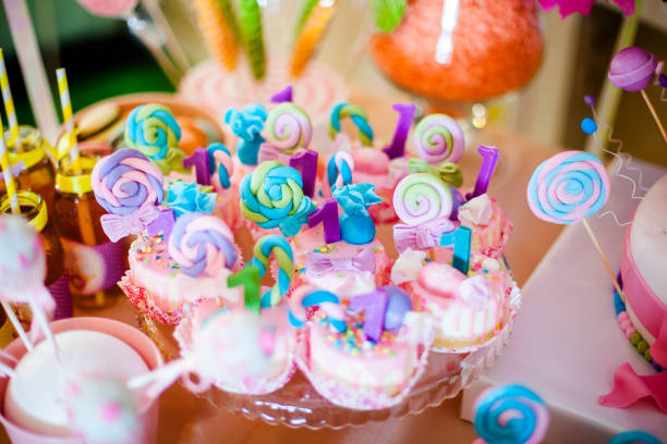 Pink and blue cupcakes with colored lollypops for candy bar.