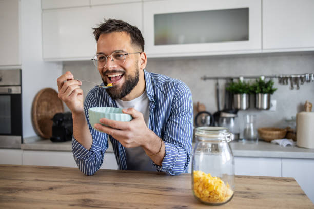 istock Man enjoying a bowl of cereal for breakfast in his kitchen 2201723980