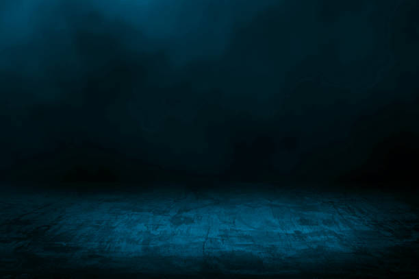 istock concrete floor with dark blue background and blue smoke float above. abstract image featuring a textured concrete floor in a dimly lit space filled with fog or mist. 2201724434