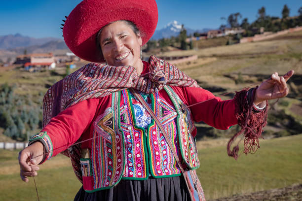 istock Peruvian woman spinning wool by hand in Chinchero, Sacred Valley, Peru 2201724438