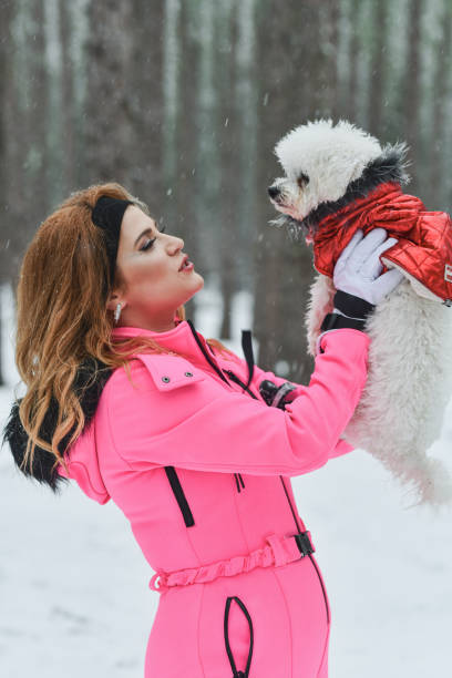 istock Beautiful Female Admiring Het Cute Maltese Dog While It's Snowing 2201724694