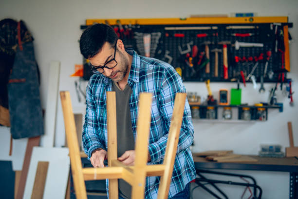 istock Craftsman assembling a wooden stool in his garage 2201725000