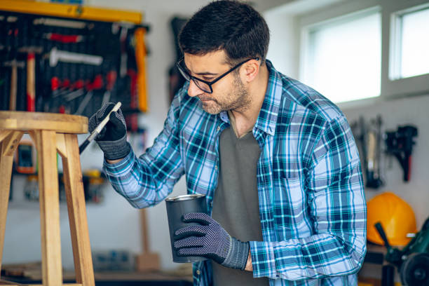 istock Craftsman painting his wooden stool product in his workshop 2201726162