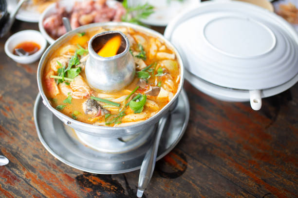 Tom Yum with seafood in thick soup placed on a wooden table