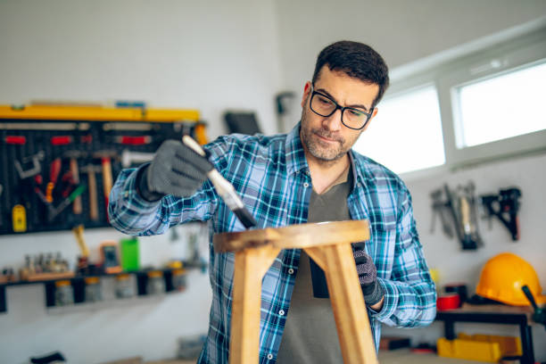 istock Craftsman painting his wooden stool product in his workshop 2201726211