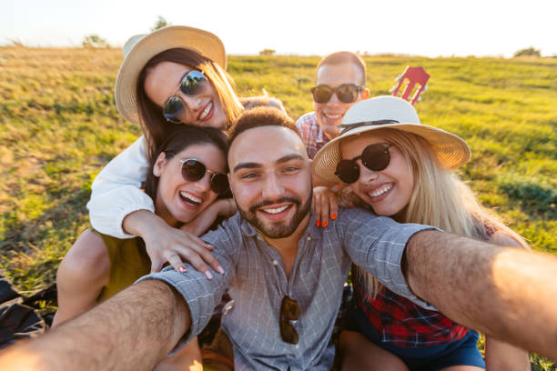 istock Group Of Friends Taking Selfies In The Field At Sunset 2201726214