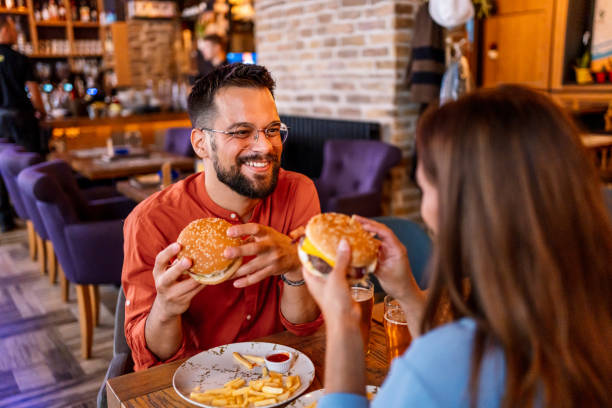 istock Couple eating burgers at the restaurant 2201729063