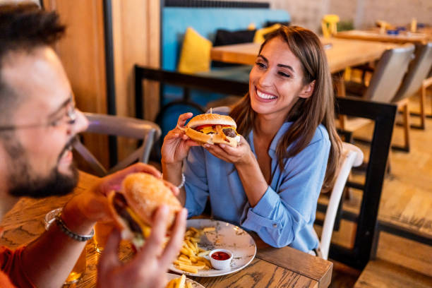 istock Couple eating burgers at the restaurant 2201729183