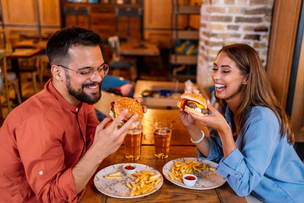 istock Couple eating burgers at the restaurant 2201729220