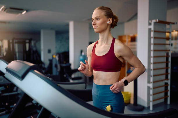istock Female athlete jogging on treadmill while working out in a gym. 2201729349
