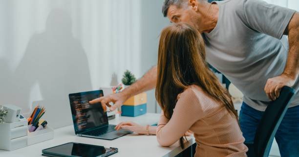 istock Senior father helps his daughter with her coding homework on laptop, family support and e-learning at home. Lifestyle family. 2201729386