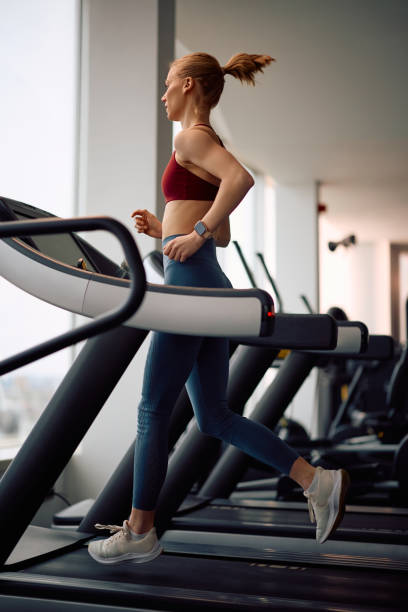istock Athletic woman running on treadmill while working out in a gym. 2201729401