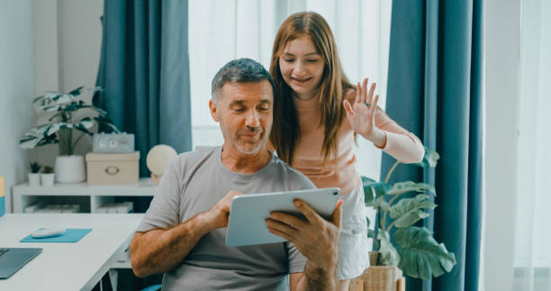 istock Senior father and daughter share a joyful moment as they make a video call on a digital tablet, emphasizing family bonding and technology use. Lifestyle family. 2201729419