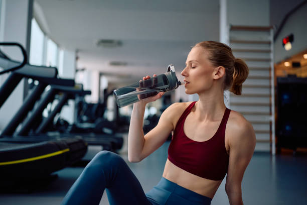 istock Young sportswoman having water break while working out in a gym. 2201729618