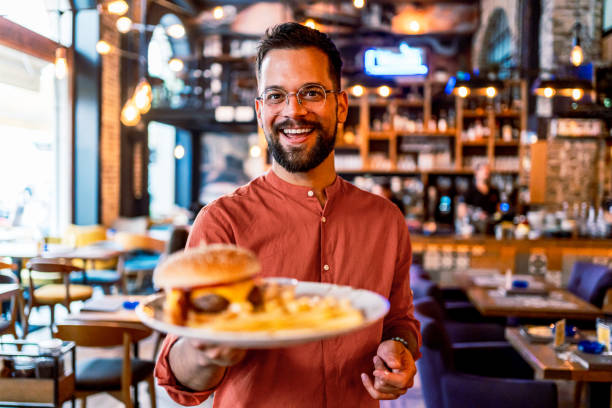 istock Happy man holding a plate with a tasty burger 2201730119