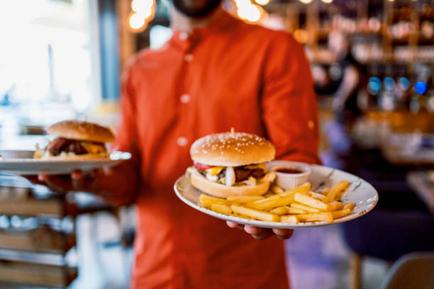 istock Man holding plates with tasty burgers 2201730227