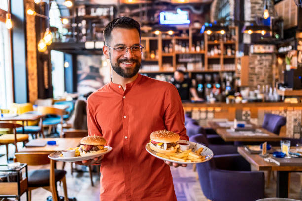 istock Young man holding plates with tasty burgers 2201730555