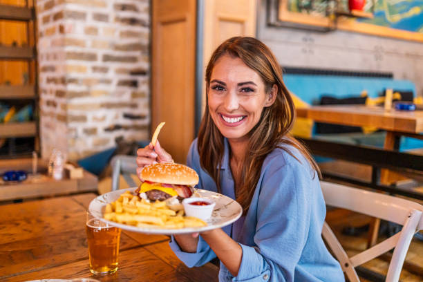 istock Young woman holding a plate with a tasty burger 2201730608