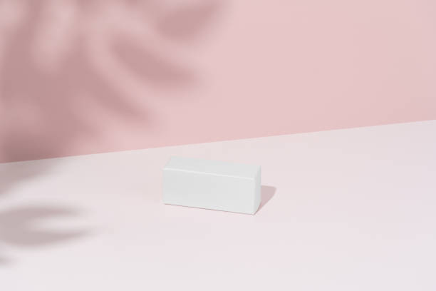 istock White mockup box on a pink background with a shadow from a branch. Concept of branded packaging, presentation and advertising of a new product. Template for design 2201730871