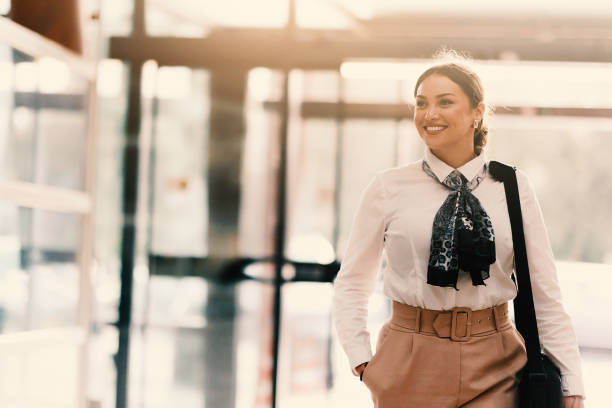 istock Empowered Latina businesswoman strides confidently through modern office. 2201731715