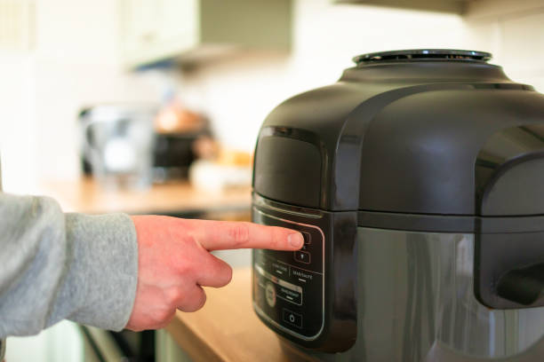 istock Man using air fryer in kitchen at home 2201734808