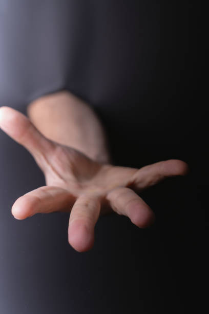 istock photo Dynamic Expression of Human Hand Gesture in Minimalist Black Space Highlighting Touch, Connection, Communication, and Emotion through Outstretched Fingers Reaching for Engagement 2201734983