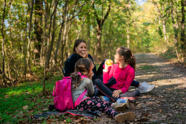 istock Children eat an apple with their mother while sitting on the ground 2201735899