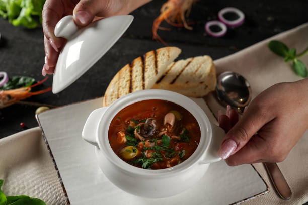 istock menu for a restaurant, seafood tomato soup with olives in a pot, beautiful presentation and serving on a black background 2201736192