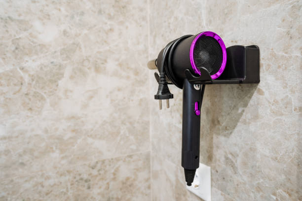 istock A hair dryer is securely hanging on the wall in a bathroom, which is a common sight in many homes and establishments, providing convenience for users who need to style their hair 2201737863