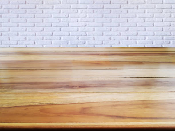 istock Empty brown wooden table placed in front of white brick wall as background. 2201739065