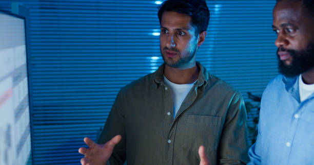 Studio Photo Of A Young Man Talking And Explaining With Hand Gestures, Wearing Patterned Tshirt On Black Background, Great For Communication, Presentation, Coaching, And Instructional Content.
