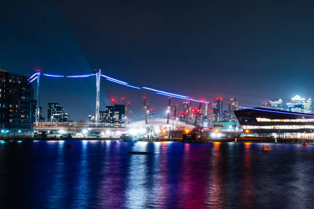 Illuminated cable car and cityscape reflecting in the thames river at night in london, united kingdom