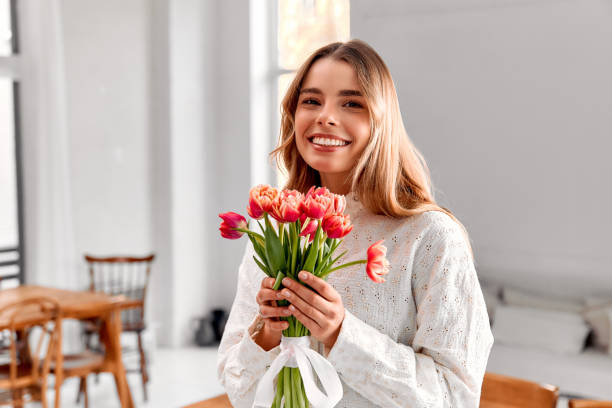 istock Smiling woman with tulip bouquet. 2201743176
