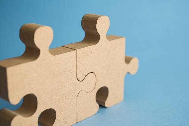 istock Two pieces matching puzzle jigsaw on blue background copy space. 2201743845