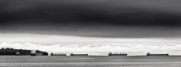 Container ships docked in English Bay waiting to enter the Vancouver Burrard Inlet harbor, British Columbia