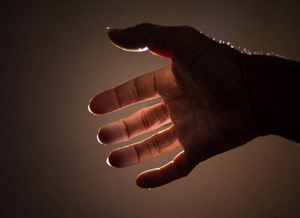 istock Hand and finger gestures perform magic on black background with light and shadow. Looks mysterious and scary. 2201746325