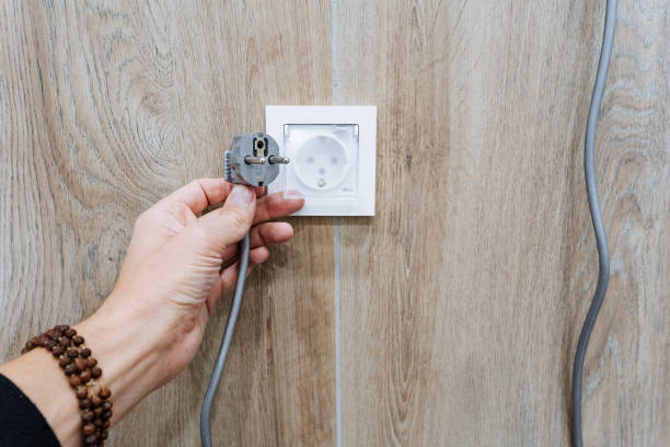 istock A person is carefully plugging an electrical plug into a wall outlet to ensure a secure connection, allowing essential appliances to function safely and effectively all day 2201748033