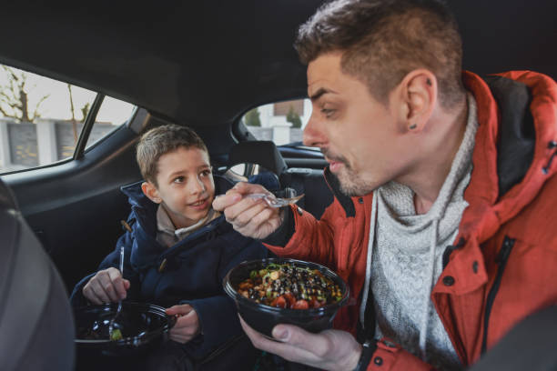 istock Happy Father and Son Enjoying Wholesome Meal Inside the Car 2201748167