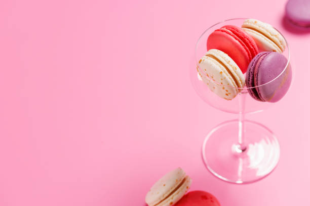 A delightful assortment of colorful macaroons arranged on a vibrant pink background