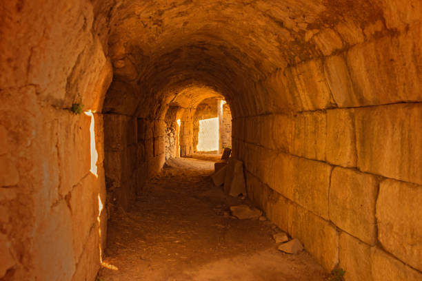 istock Ancient stone corridor of a historical site in Turkey bathed in warm orange sunlight 2201752795
